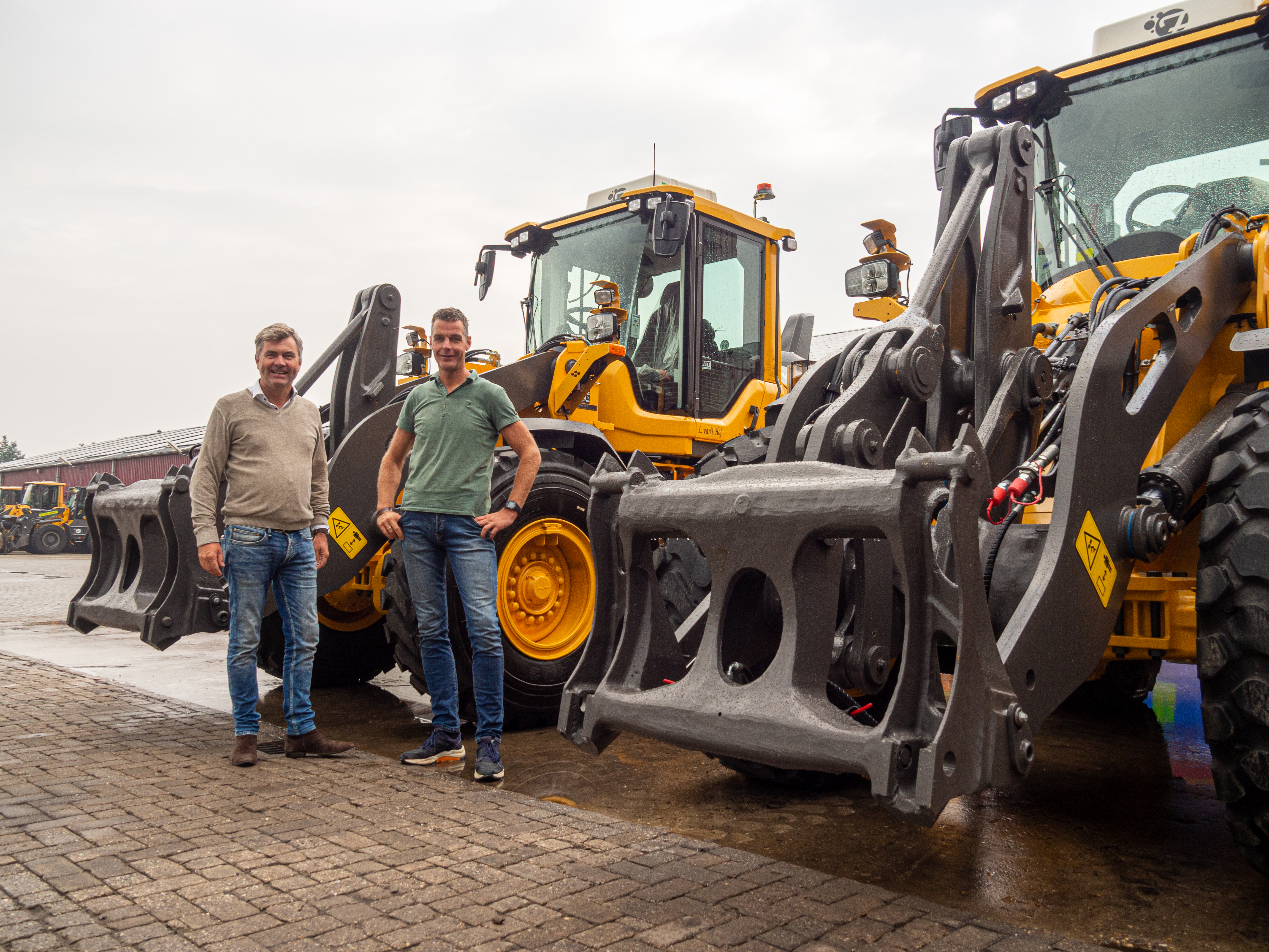 Twee mannen bij de nieuwe Volvo wielladers met puinrek