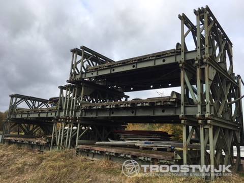Stapel stalen noodbruggen (baileybruggen) op het buitenterrein, een van de veilingstukken