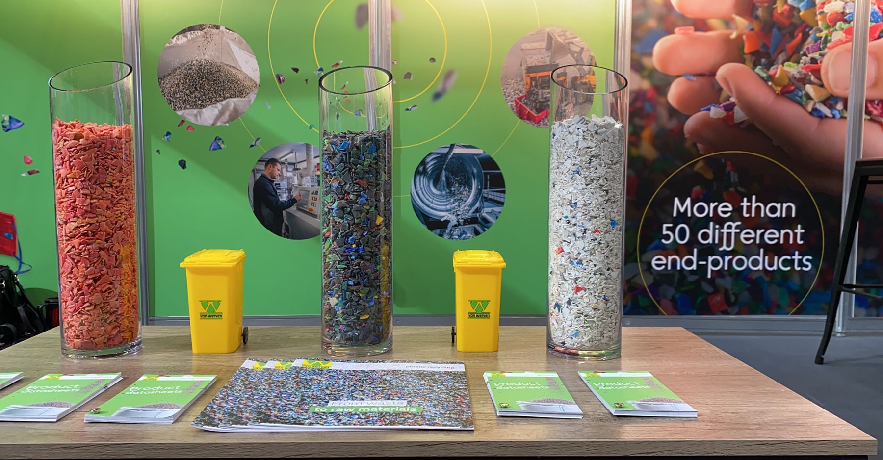 Beursstand van Van Werven Plastic Recycling met glazen cilinders vol gekleurde kunststofsnippers en productbladen, met de tekst 'More than 50 different end-products'