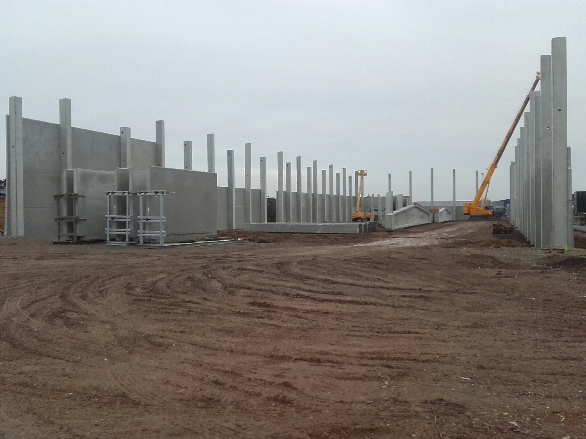 Het skelet van de nieuwe hal in Lanaken: betonwanden, kolommen en de telekraan