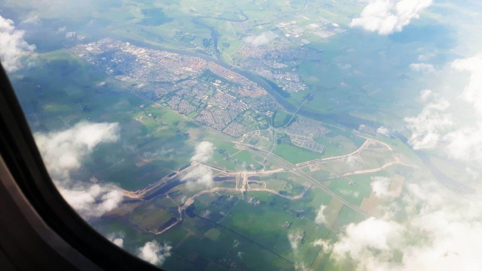 Blik uit een vliegtuigraam op Kampen en de IJssel, met het tracé van de nieuwe geul als lichte lijnen door de polder