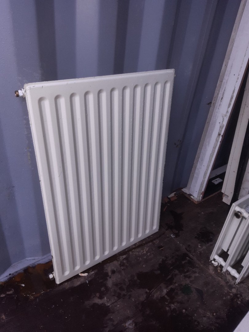Enkele paneelradiator, rechtop in de hoek van de opslagcontainer