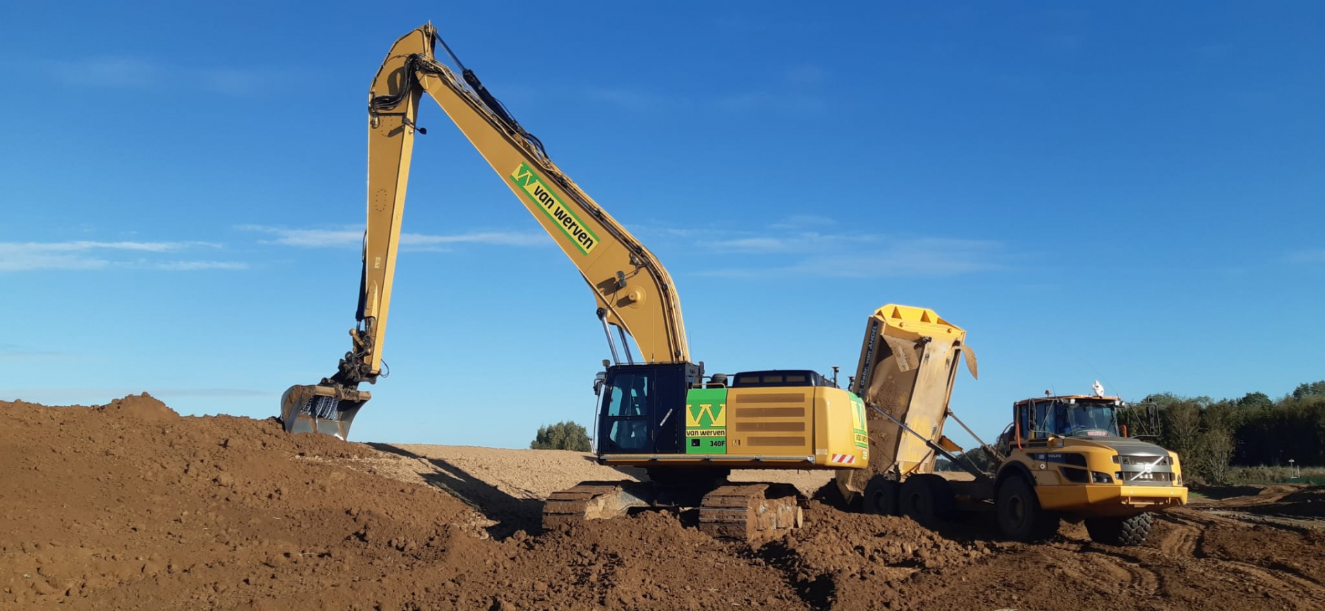 Rupskraan met lange giek laadt grond in een dumper