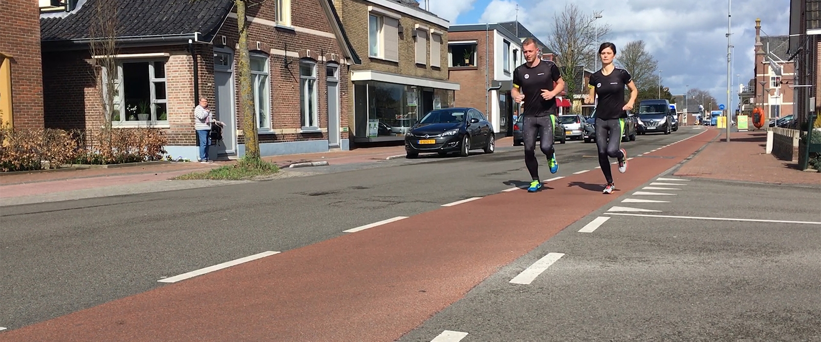 Twee hardlopers in de Van Werven-runningkleding onderweg door het dorp