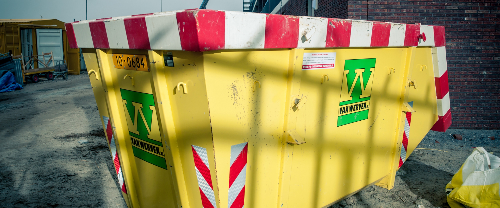 Gele Van Werven-afzetcontainer op een bouwterrein
