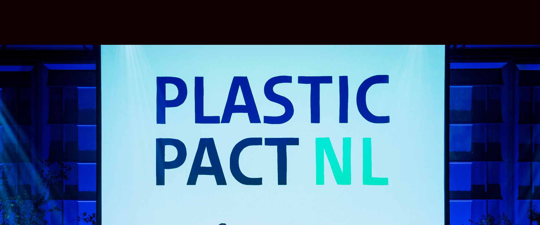 Het Plastic Pact NL-logo op een groot scherm tijdens de ondertekening