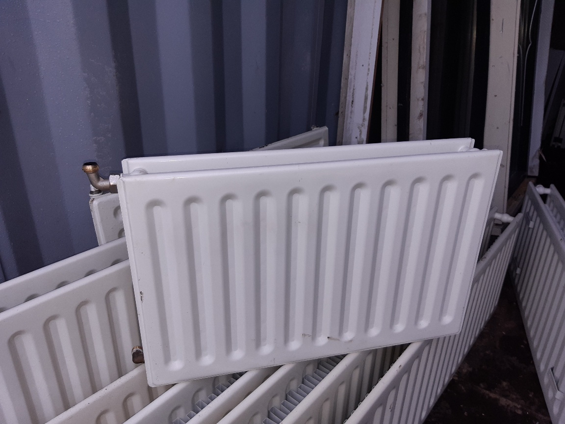 Dubbele paneelradiator met aansluiting linksboven, tussen de andere radiatoren in de opslag