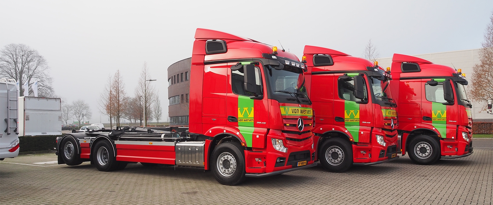 Drie nieuwe rode Mercedes Actros-vrachtwagens van Van Werven op een rij