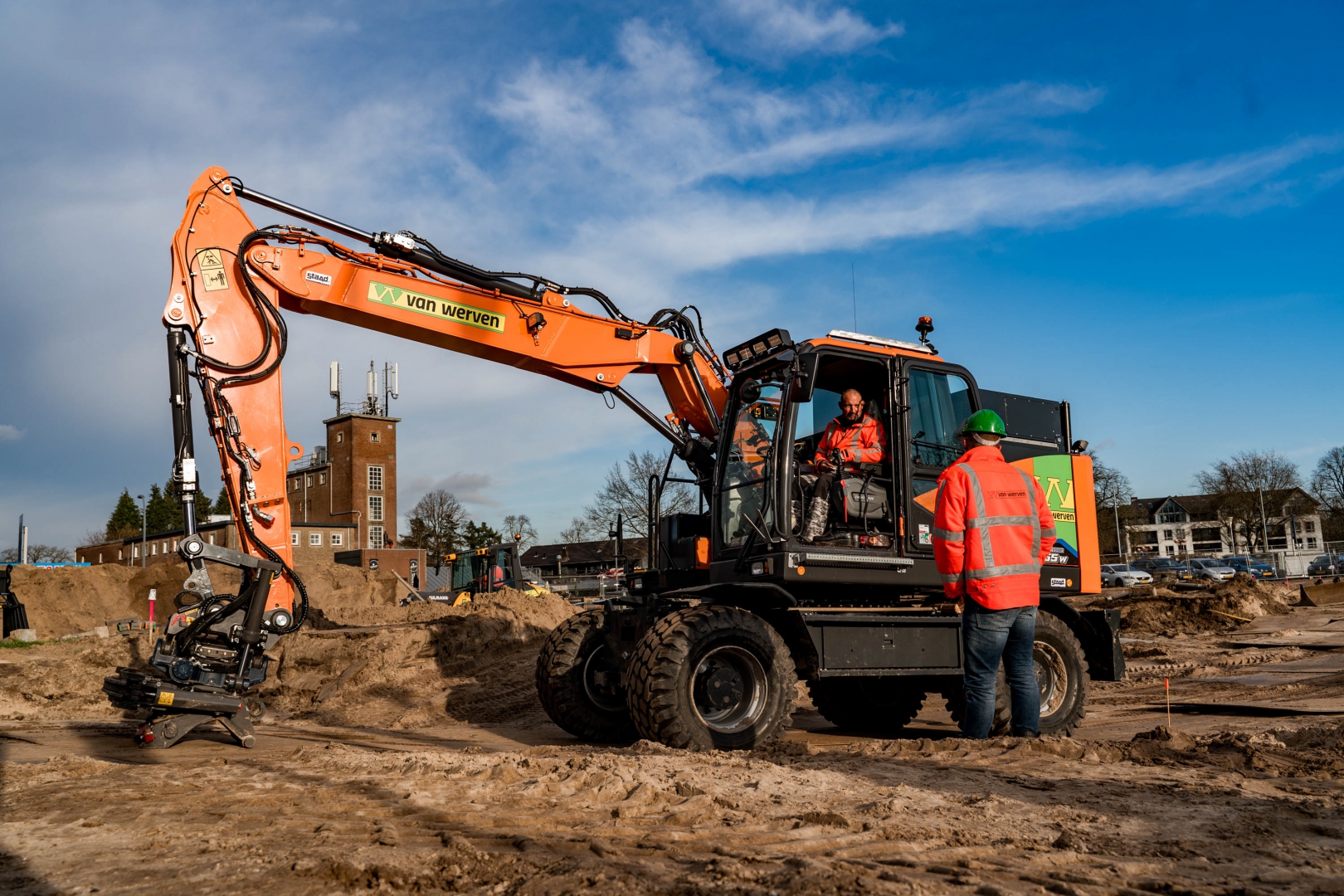 Machinist en collega bij een Doosan mobiele graafmachine van Van Werven