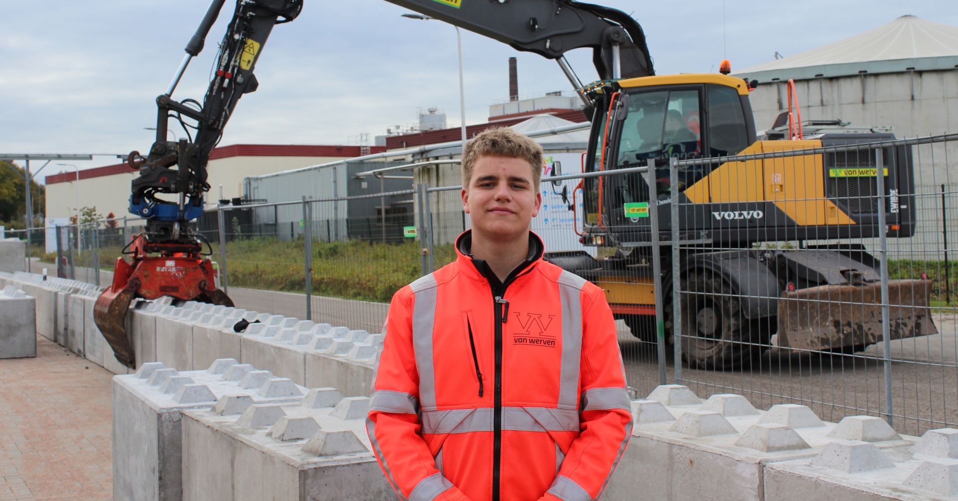 Stagiair in Van Werven-werkjas voor een mobiele graafmachine