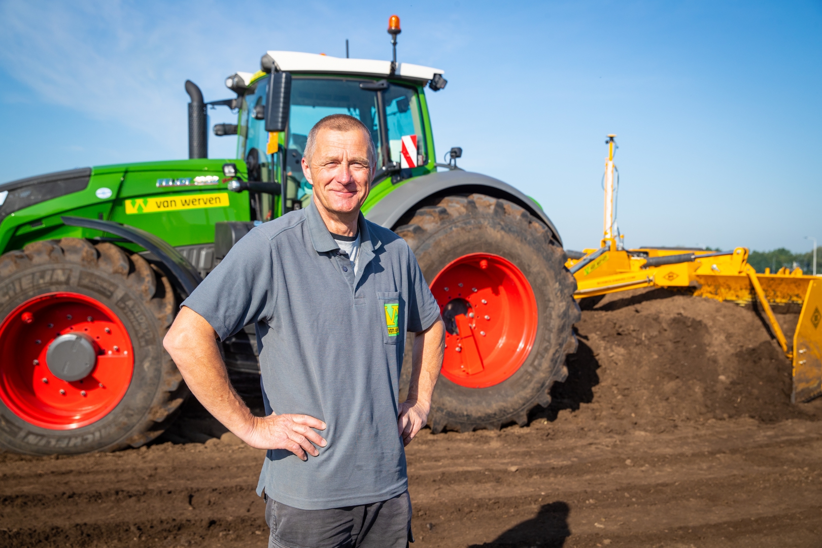 De machinist staat in Van Werven-polo voor zijn groene Fendt, met de gele kilverbak erachter