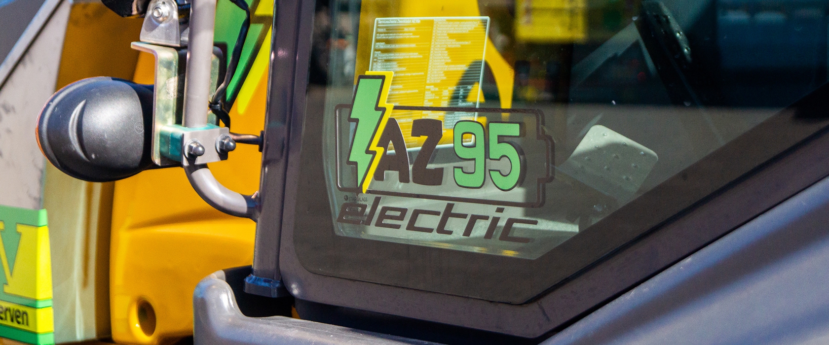 Sticker 'AZ 95 electric' met bliksemschicht op de cabineruit van de elektrische Ahlmann shovel