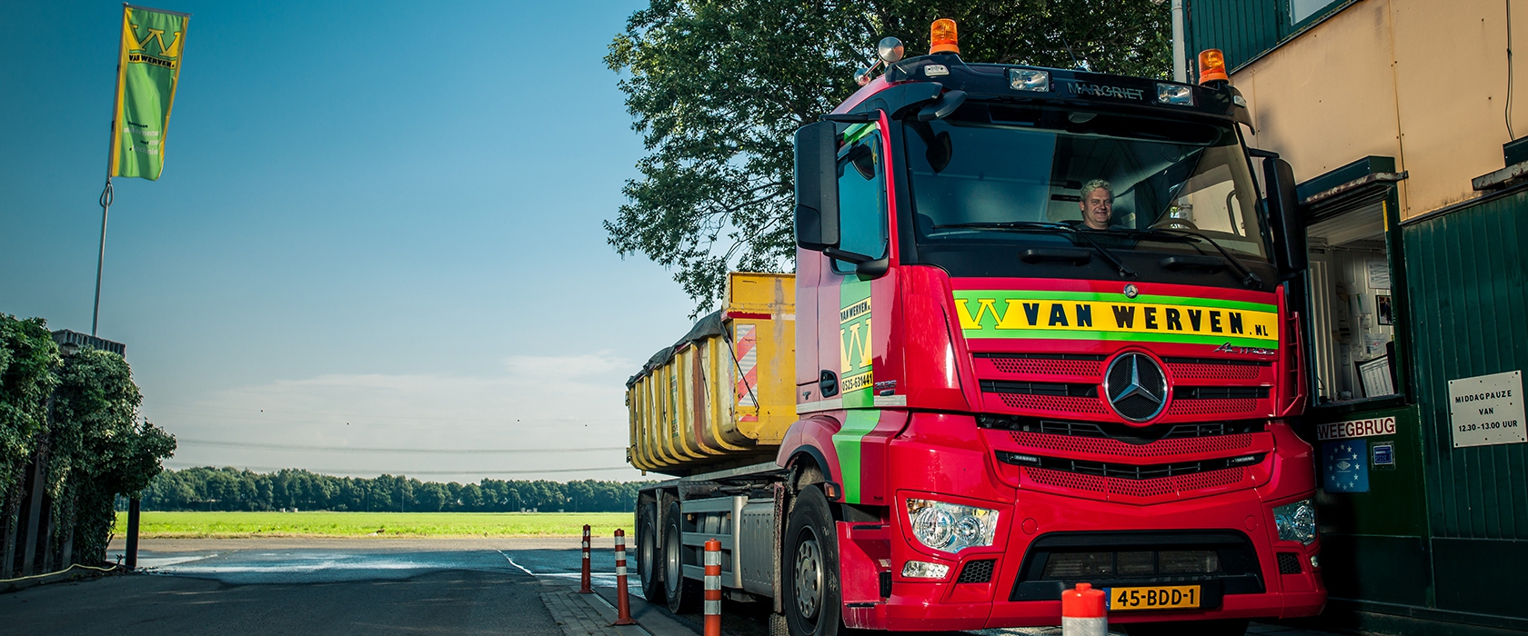 Vrachtwagen van Van Werven met gele container staat op de weegbrug bij het loket