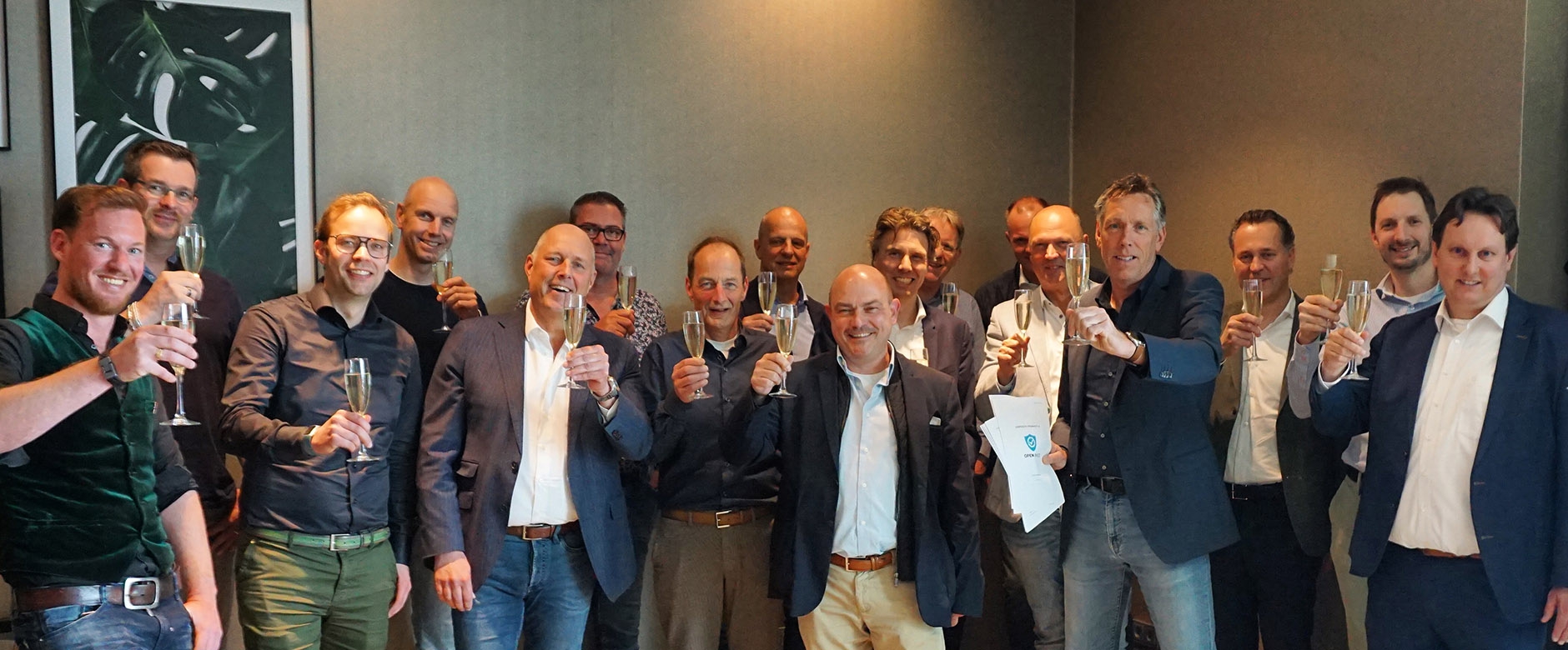 Zestien mannen heffen het glas champagne na het ondertekenen van de samenwerking voor emissievrije stadslogistiek