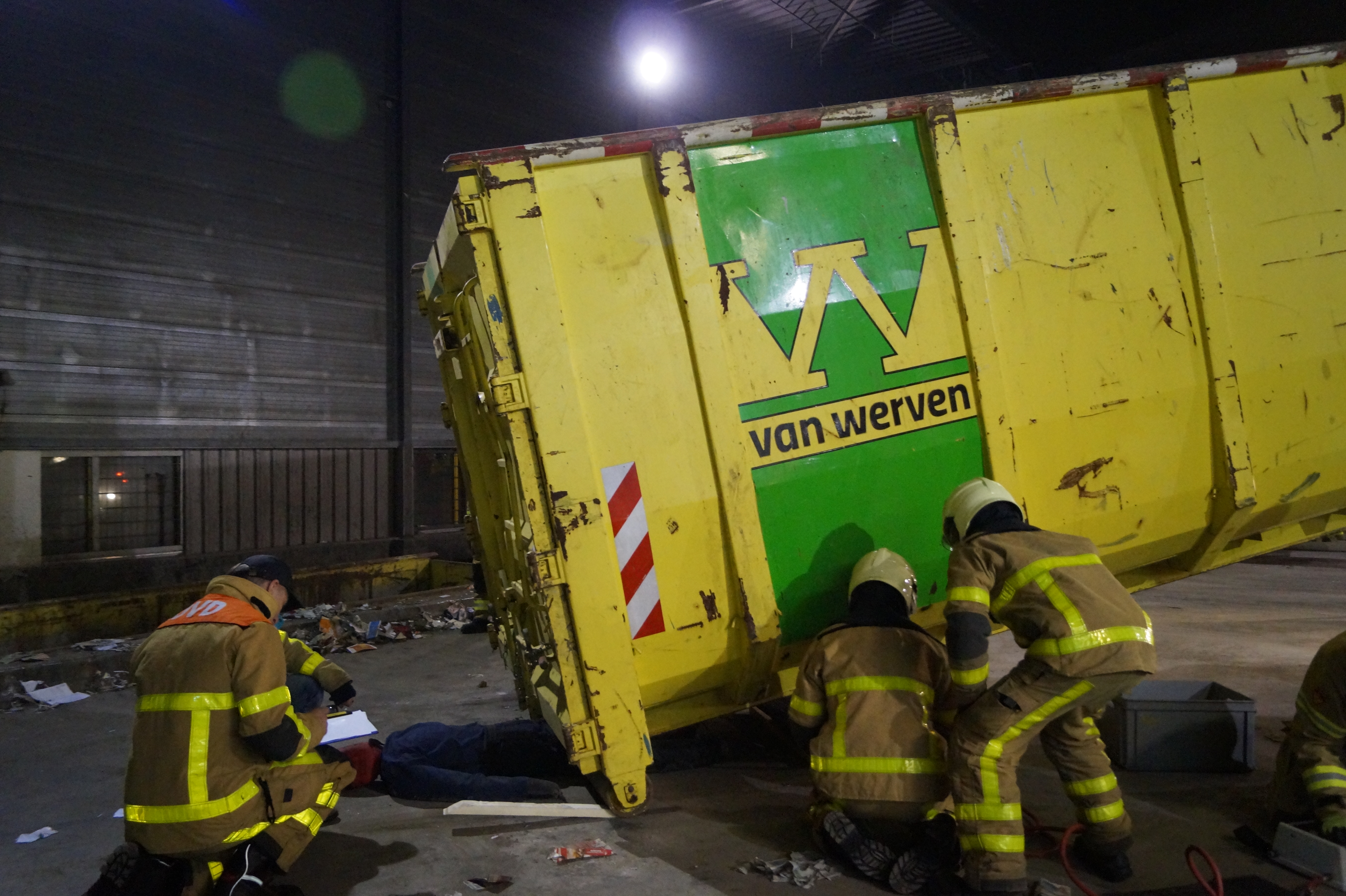 Brandweerlieden bevrijden een slachtoffer onder een gekantelde container tijdens de oefening