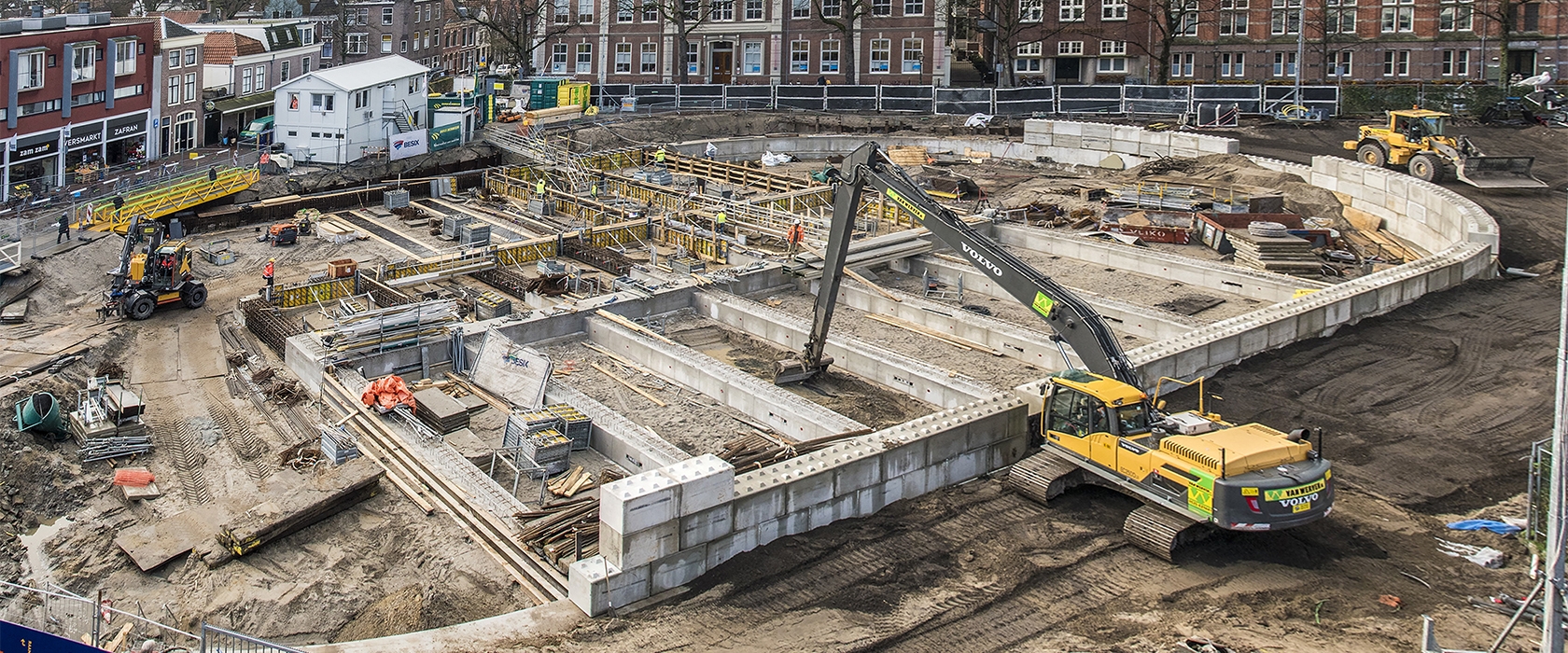 Luchtoverzicht van de ronde bouwkuip aan de Garenmarkt, met het raster van de vloervelden en een rupskraan met lange giek van Van Werven
