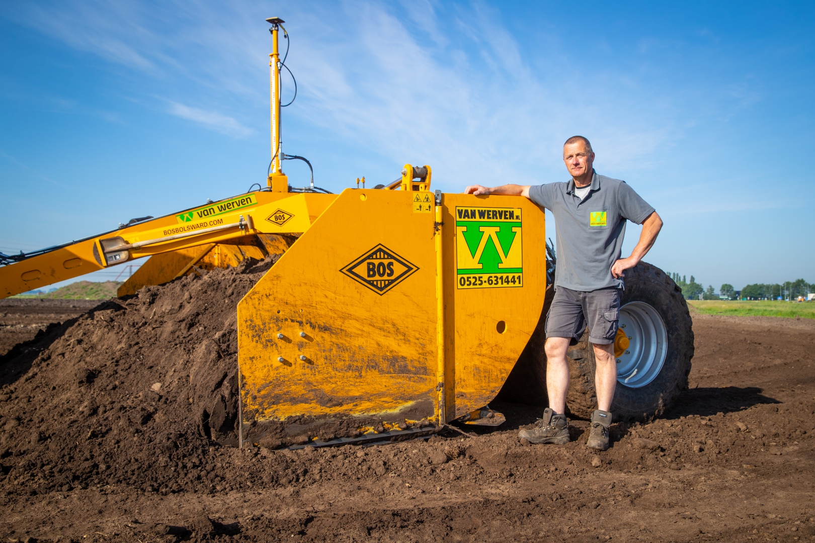De machinist leunt op de gele Bos-kilverbak met het Van Werven-logo