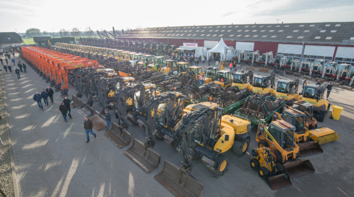 Luchtfoto van de open dagen: lange rijen graafmachines, shovels en tractoren op het terrein met bezoekers ertussen