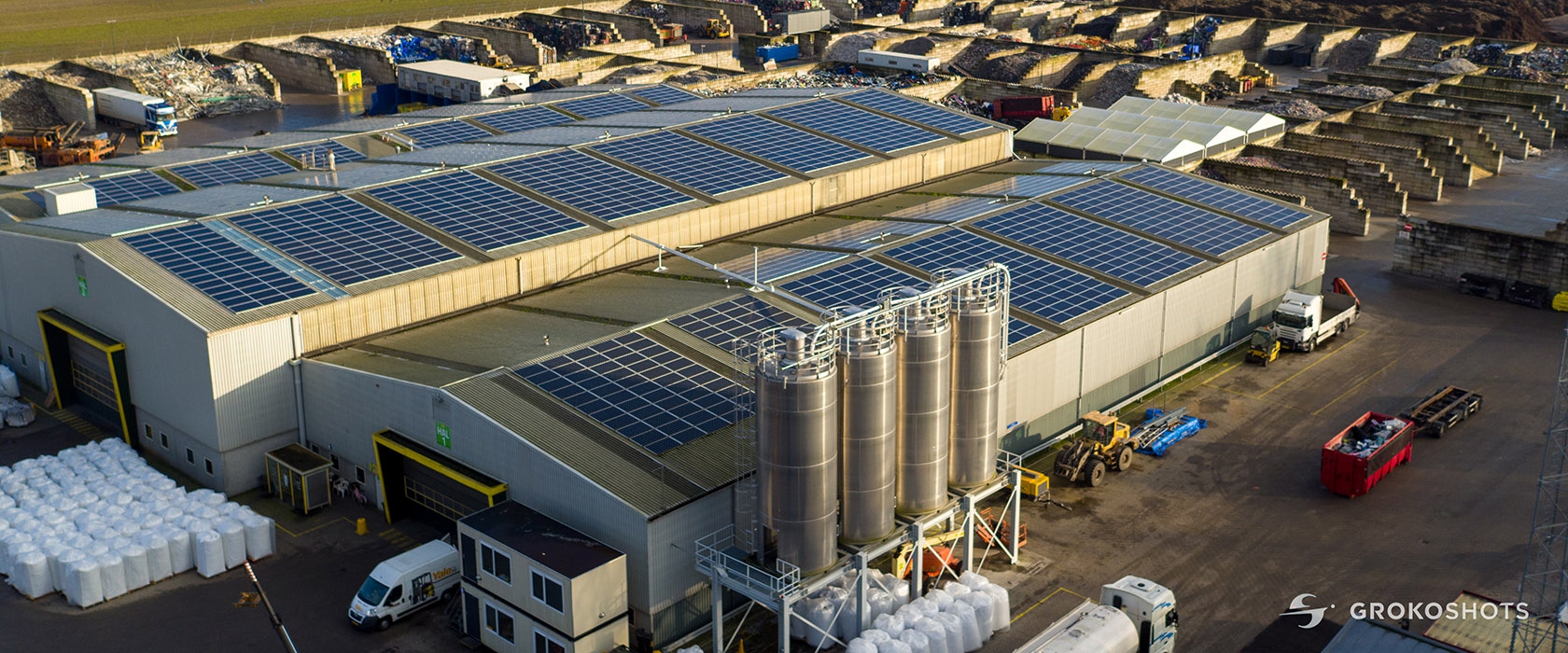 Luchtfoto van de recyclinglocatie van Van Werven met daken vol zonnepanelen en vier rvs-silo's