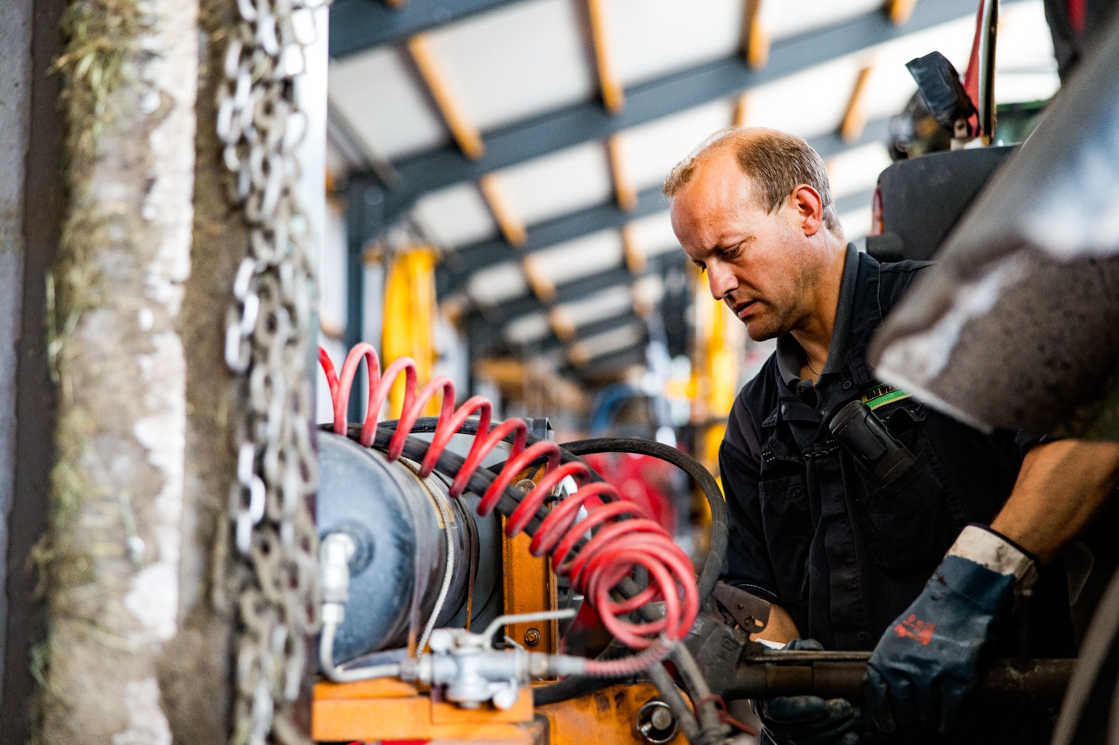 Monteur werkt aan de luchtleidingen van een machine in de werkplaats