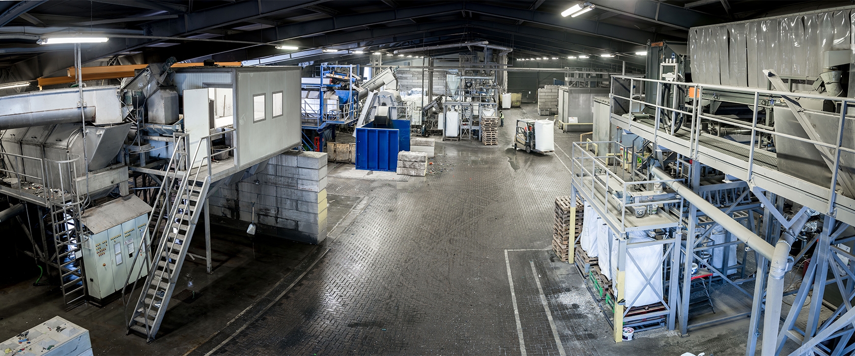 Overzicht van de kunststofrecyclinghal met wasinstallatie en big bags