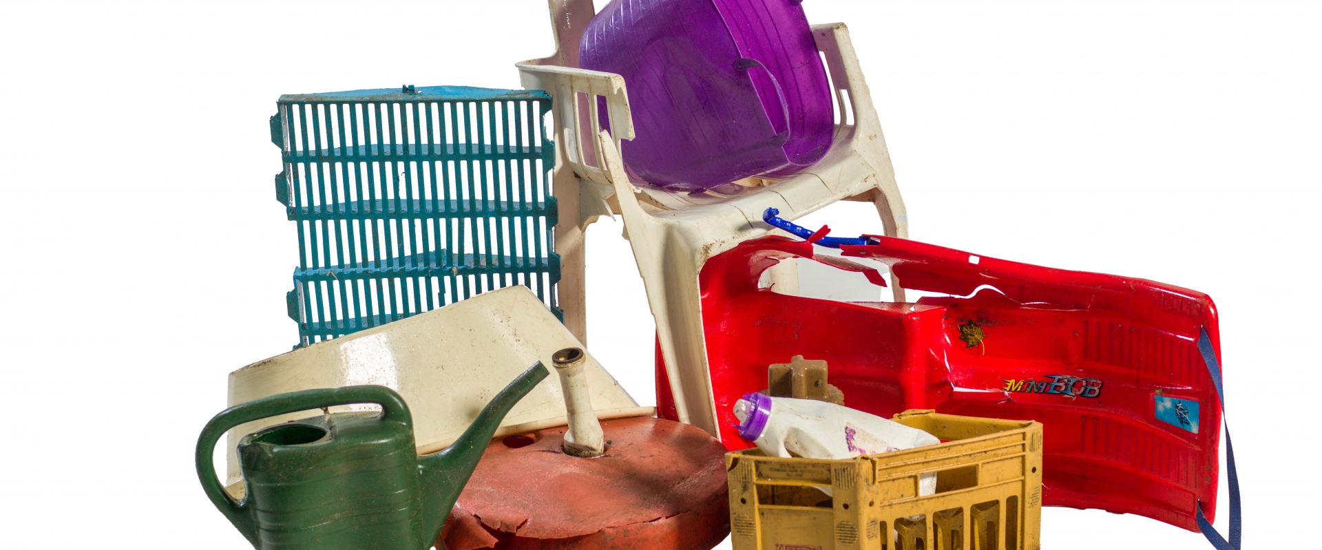 Ingezameld hard huishoudplastic: krat, gieter, tuinstoel en slee
