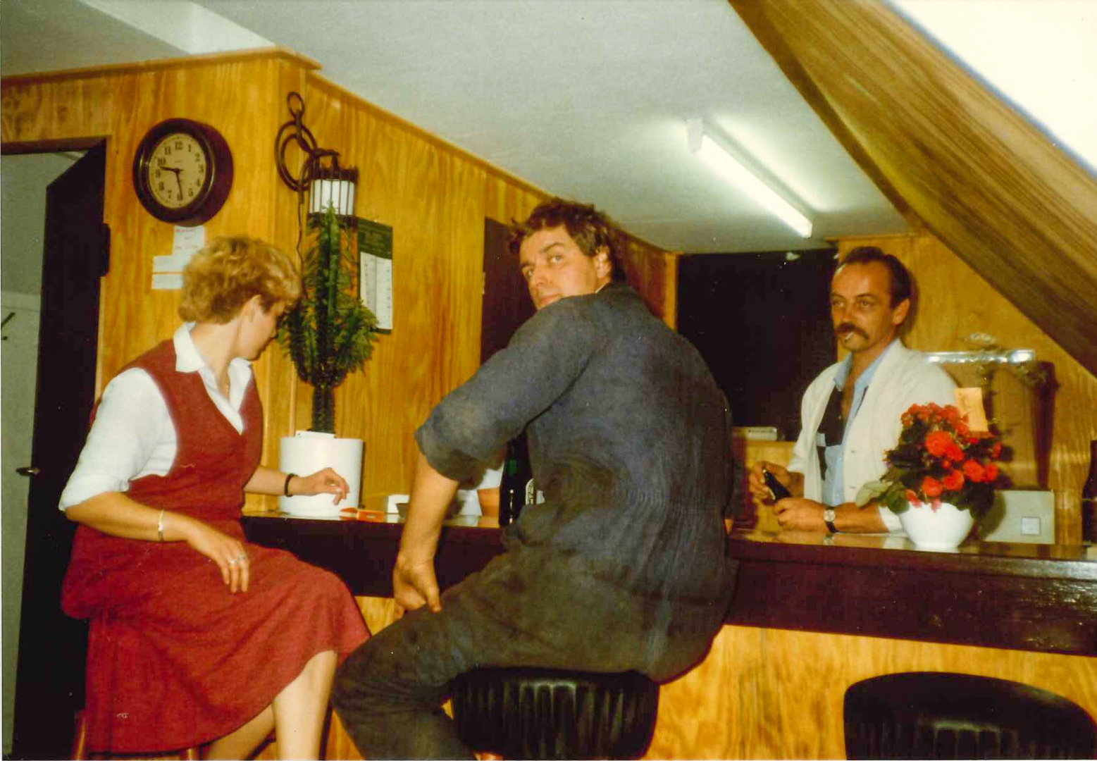 Foto uit de jaren tachtig: Hendrik in overall aan de bar van de kantine, met een vrouw in rode jurk en de barman erachter