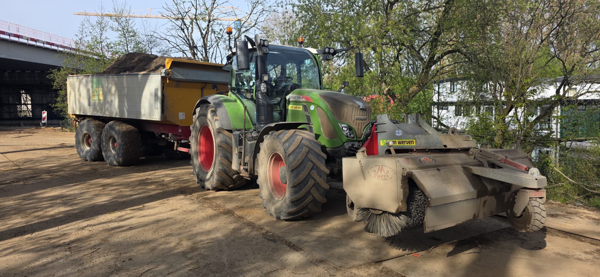 Fendt-tractor van Van Werven met rolbezem en kipper op een bouwlocatie