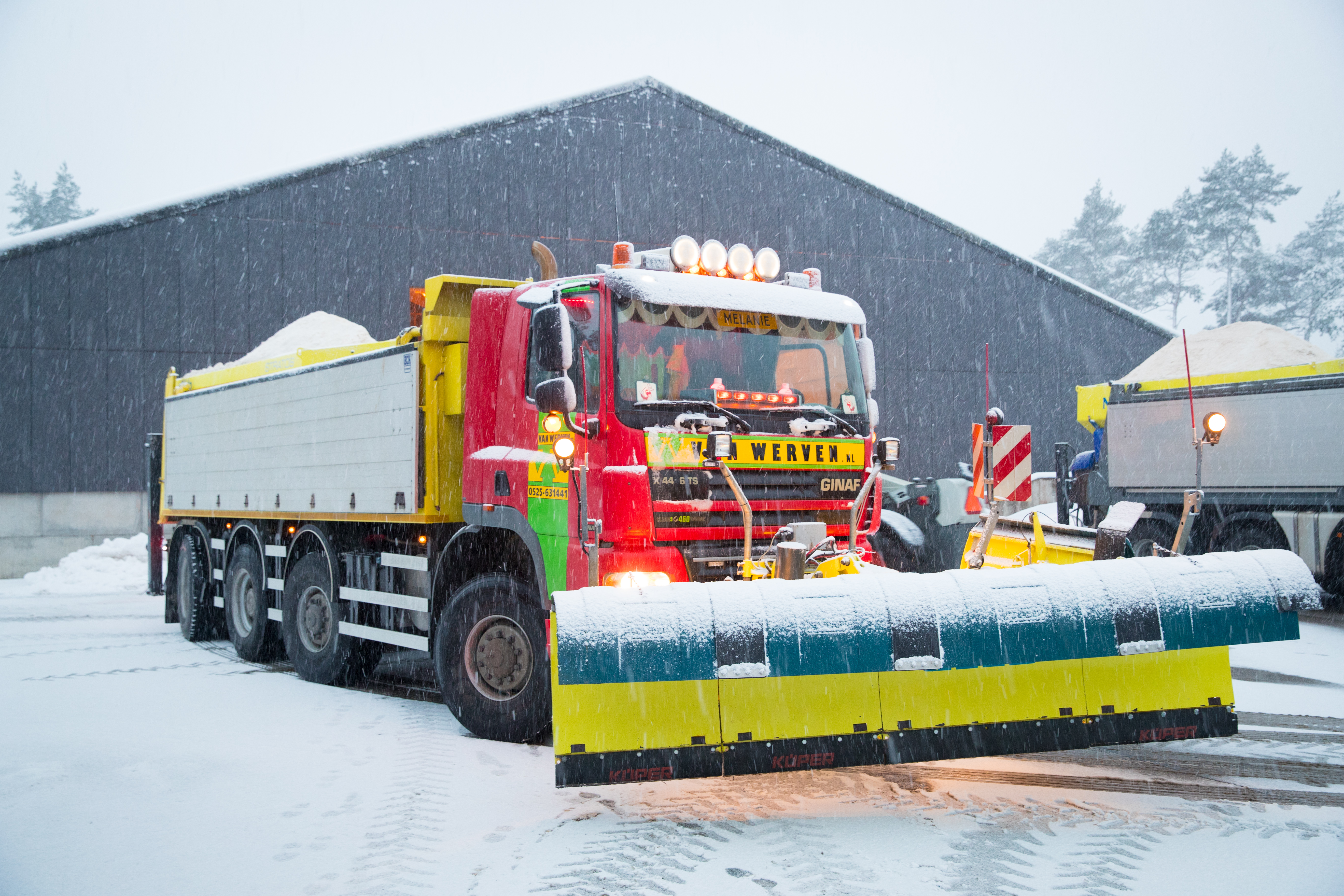 Ginaf-strooiwagen met sneeuwploeg in de sneeuwval bij de loods