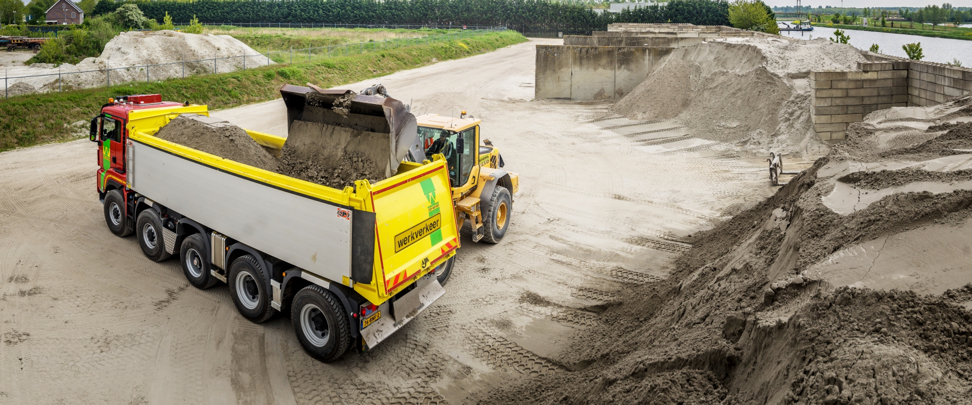 Shovel laadt zand in een kipper op het gronddepot van Van Werven