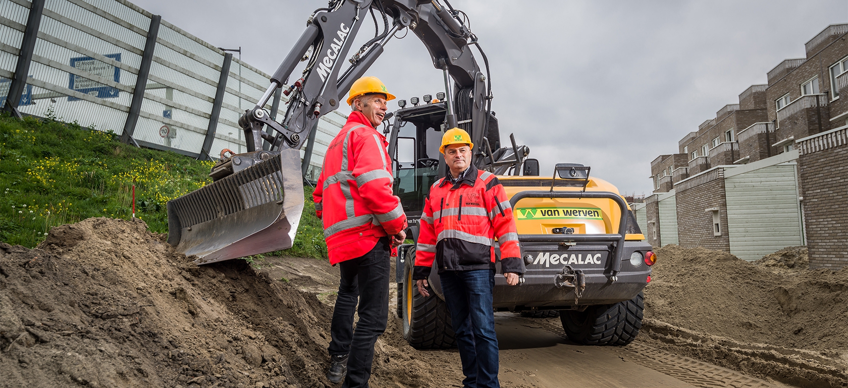 Medewerkers van Van Werven in bedrijfskleding bij een rij gele containers en materieel