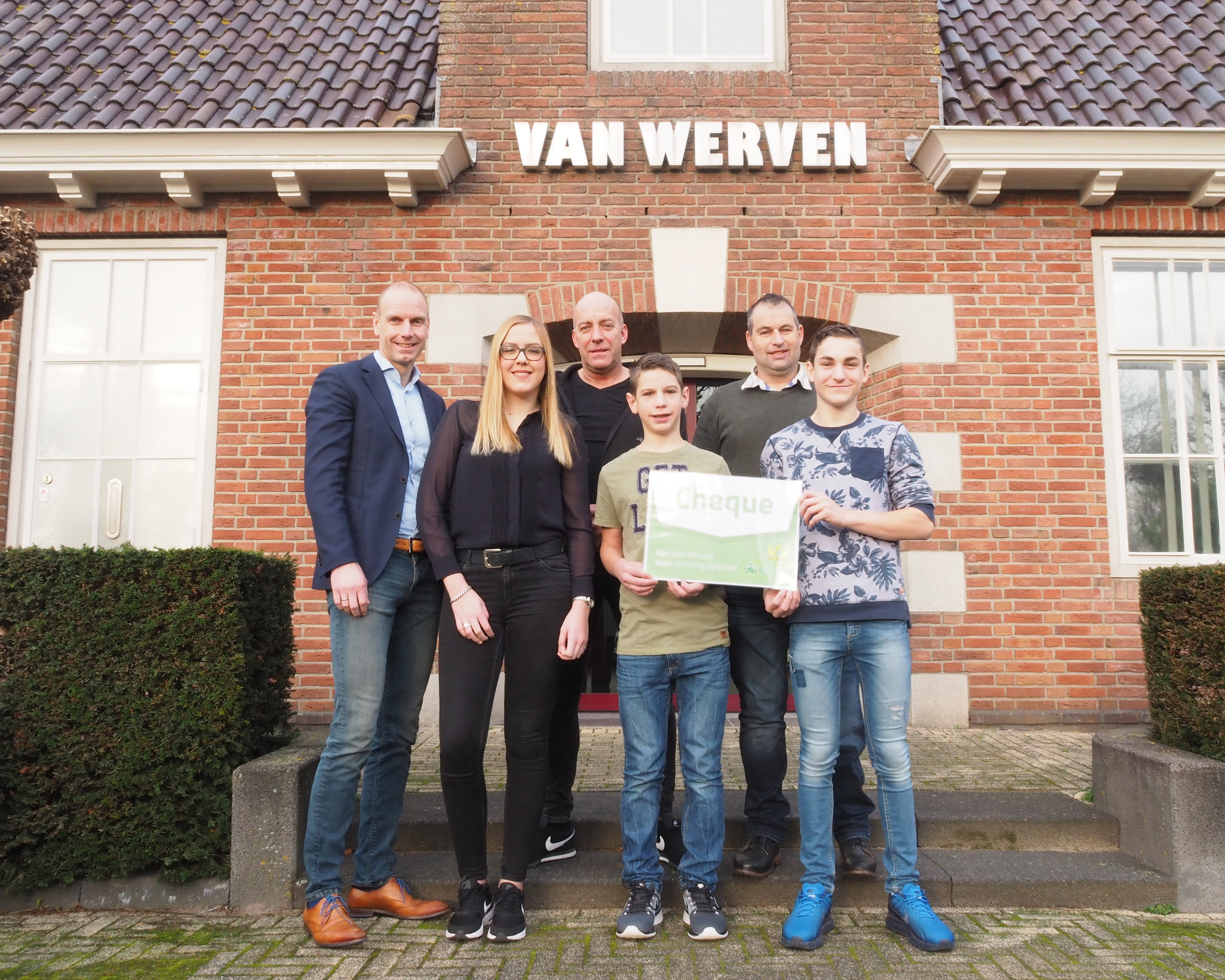Vertegenwoordigers van de goede doelen met de cheque voor het kantoor