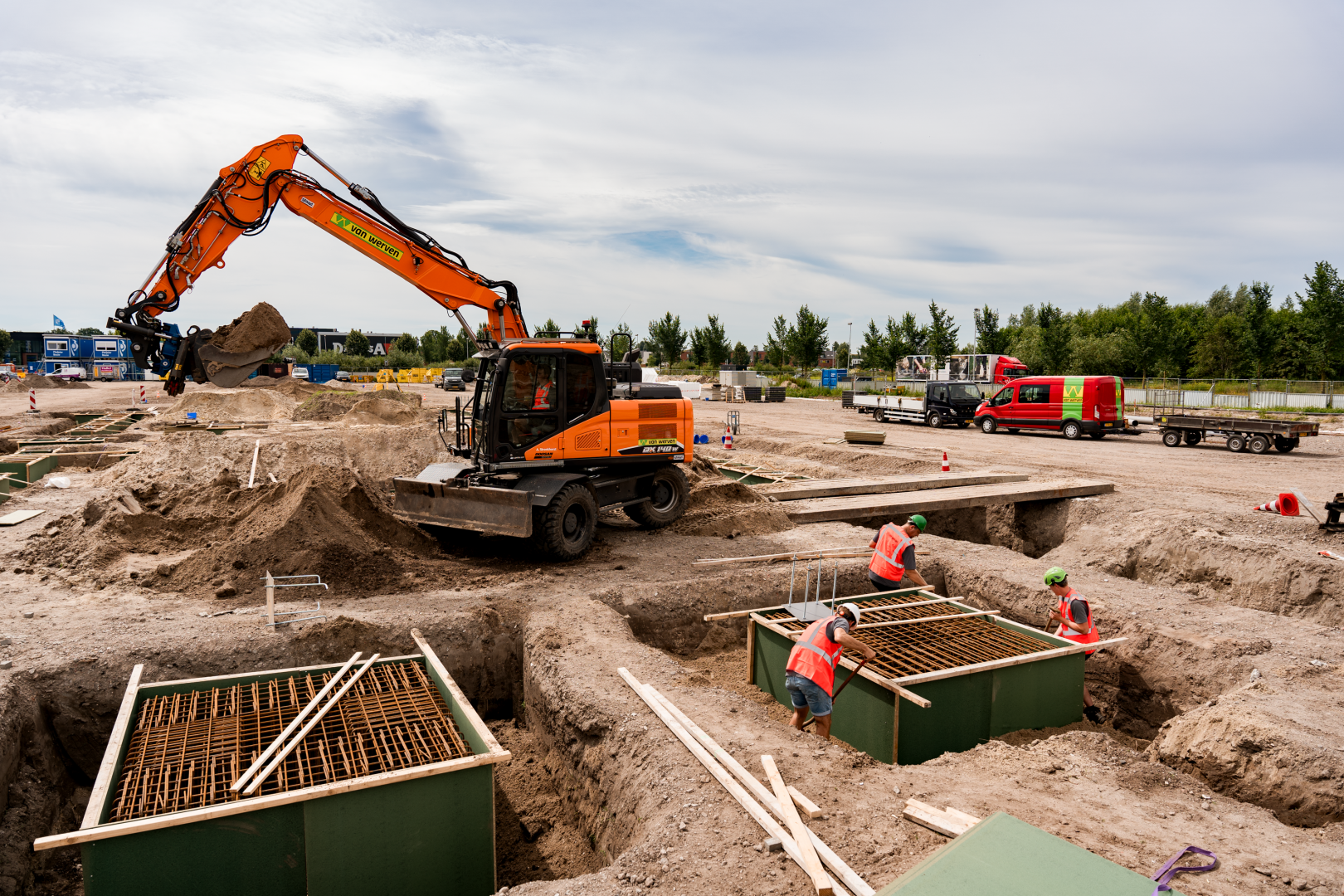 Mobiele kraan van Van Werven graaft funderingen uit op een bouwterrein