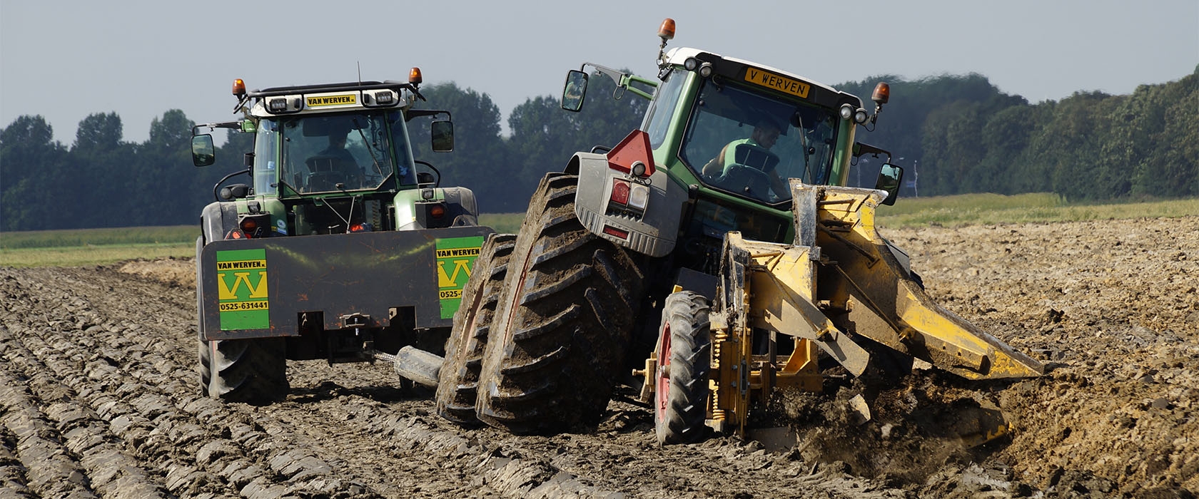 De diepploegcombinatie van achteren gezien: de trekker helt in de voor terwijl de gele ploeg de grond keert