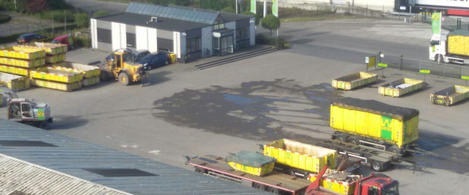 Het terrein van recyclingvestiging Balkbrug met shovel, containers en het kantoorgebouw