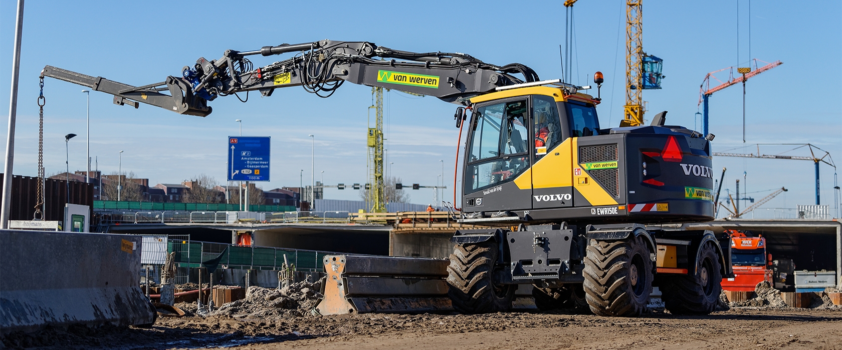 Volvo EWR150E mobiele kraan van Van Werven aan het werk op een bouwterrein langs de snelweg