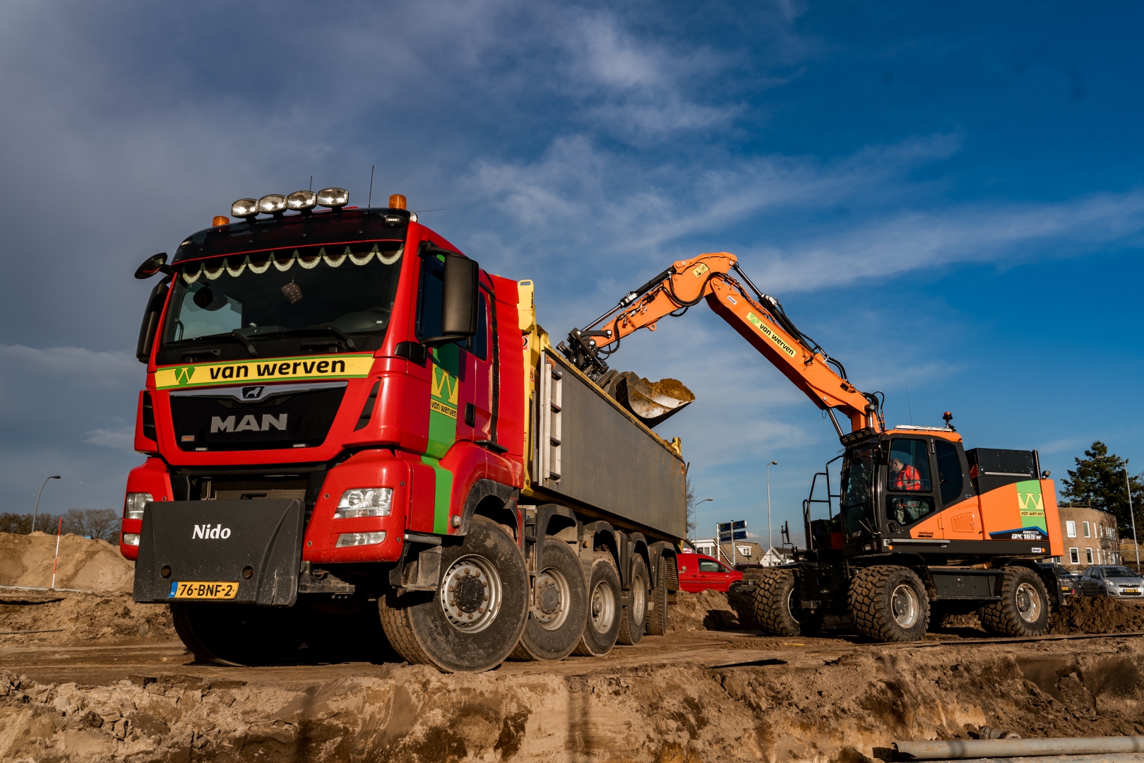 Doosan graafmachine laadt een MAN-vrachtwagen van Van Werven met grond