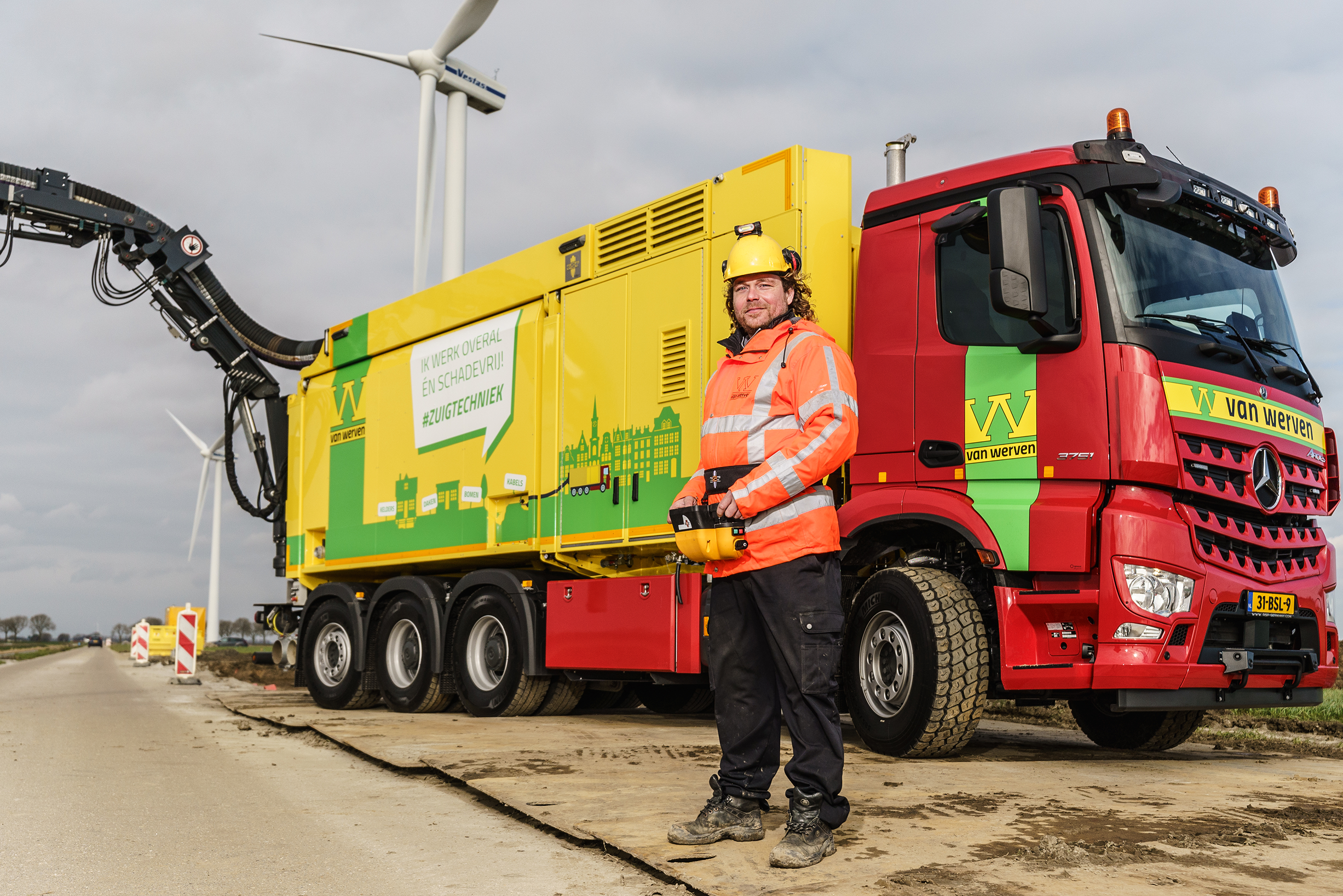 Een medewerker met afstandsbediening poseert voor de zuigwagen met de tekst 'Ik werk overal en schadevrij! #zuigtechniek'